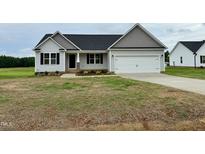 Charming one-story home featuring gray siding, black shutters and complementary landscaping at 207 N Movado Trl, Kenly, NC 27542