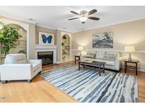 Inviting living room with fireplace, custom built-ins, and stylish striped rug at 300 Summerwalk Cir, Chapel Hill, NC 27517
