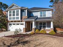 Charming two-story home featuring stone accents, a two-car garage, and a landscaped front yard at 3059 Hyco Lake Ct, Fuquay Varina, NC 27526