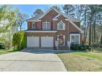 Charming two-story brick home featuring a two-car garage and a well-maintained lawn at 308 Sylvan Way, Chapel Hill, NC 27516