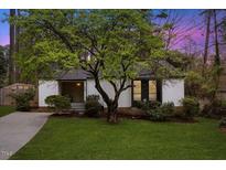 Charming single-story home showcasing mature tree, well-manicured lawn, and inviting entrance at 309 Ashebrook Dr, Raleigh, NC 27609