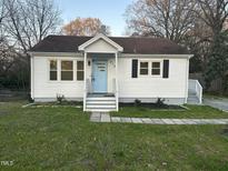 Charming single-story home featuring a bright blue front door and well-maintained lawn at 512 Texas Ave, Burlington, NC 27217