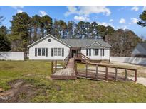 Charming single story home with wooden ramp and white siding against a backdrop of mature trees at 5437 Grasshopper Rd, Raleigh, NC 27610