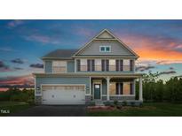 Charming two-story home featuring a two-car garage, well-kept lawn, and inviting front porch at 549 Freedom Trail Dr, Willow Springs, NC 27592