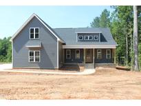Charming two-story home featuring a covered front porch, gray siding, and well-manicured landscaping at 65 Stream View Way, Spring Hope, NC 27882