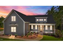 Charming two-story home showcasing its inviting front porch and meticulously landscaped front yard at 65 Stream View Way, Spring Hope, NC 27882