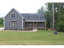 Charming home featuring gray siding, a welcoming front porch, and a lush green lawn at 65 Stream View Way, Spring Hope, NC 27882