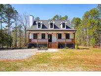 Charming two-story home with a inviting front porch and well-manicured landscaping at 692 Port Dr, Henderson, NC 27537