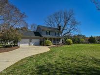 Charming two-story home with a two-car garage, large lawn, and mature landscaping on a sunny day at 10317 Lake Wheeler Rd, Fuquay Varina, NC 27526