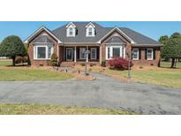 Charming single-Gathering brick home with a landscaped front yard and curved driveway at 1055 Tilghman Rd, Dunn, NC 28334