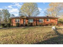 Charming brick home featuring a cozy entrance and well-maintained front yard at 1122 Snow Hill Rd, Durham, NC 27712