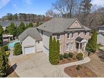 Beautiful brick home with a two-car garage and a pool in the backyard, landscaped for privacy at 116 Arlen Park Pl, Holly Springs, NC 27540