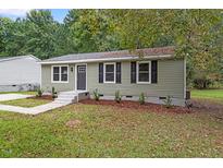 Charming single-story home features updated landscaping and stylish exterior with newly painted door and shutters at 1209 Freeman Dr, Sanford, NC 27330