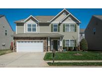 Charming two-story home with stone accents, a two-car garage, and well-maintained landscaping at 1403 Copper Cir, Mebane, NC 27302