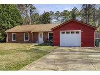 Charming single-story home with a brick exterior, attached garage, and well-manicured lawn at 1418 Suterland Rd, Cary, NC 27511