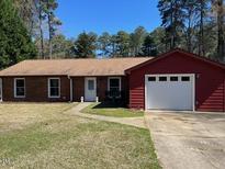 Charming single-story home with a brick facade, attached garage, and well-maintained front yard at 1418 Suterland Rd, Cary, NC 27511