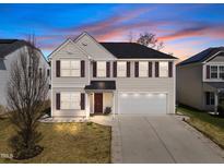 Inviting two-story home with a well-manicured lawn and a two-car garage, creating a charming curb appeal at 151 Kutter Dr, Elon, NC 27244