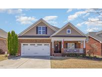 Charming brick home featuring a well-manicured lawn and attached two car garage at 187 Moss Creek Pl, Fuquay Varina, NC 27526