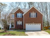 Charming two-story brick home with an attached two-car garage and a well-maintained front lawn at 2026 Prairie Ridge Ct, Fuquay Varina, NC 27526