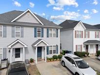 Charming townhome featuring blue shutters, a well-kept lawn, and a private driveway at 2245 Ventana Ln, Raleigh, NC 27604