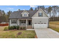 Charming home featuring a 2-car garage, inviting front porch, manicured lawn, and stylish exterior finishes at 240 Northview Dr, Middlesex, NC 27557