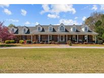 Charming brick home featuring a welcoming front porch,dormers, and beautiful landscaping in a country setting at 3030 Old Stage S Rd, Erwin, NC 28339