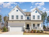Charming two-story white farmhouse with a welcoming front porch and well-maintained landscaping at 31 E Dentaires Way, Willow Springs, NC 27592
