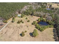 Expansive property featuring a home, pond, and wooded area, all visible from an aerial perspective at 310 Little Meadow Rd, Pittsboro, NC 27312