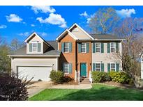 Charming two-story home with a brick facade, complemented by teal shutters and a well-manicured lawn at 3308 Forest Mill Cir, Raleigh, NC 27616