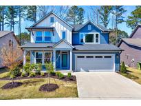 Beautiful two-story home boasts a well-manicured lawn, charming curb appeal, and an attached two-car garage at 3417 Mission Olive Pl, New Hill, NC 27562