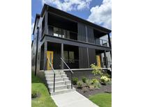 Modern two-story home featuring a striking dark exterior and a vibrant yellow front door at 409 Alston St # 101, Raleigh, NC 27601