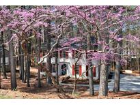 Charming two-story home with red shutters, surrounded by trees and flowering dogwoods in a serene setting at 4910 Highgate Dr, Durham, NC 27713