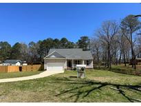 Charming single-story home with a well-manicured lawn, attached garage, and inviting front porch at 495 Cheves Rd # 495, Zebulon, NC 27597