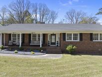 Charming brick home with a welcoming front porch and landscaped yard, perfect for enjoying the outdoors at 5705 Dean Ave, Raleigh, NC 27616