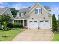 Charming two-story home featuring a two-car garage, well-manicured lawn, and classic architectural details at 5811 Shawood Dr, Raleigh, NC 27609