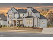 Elegant two-story home with a brick facade, complemented by a professionally landscaped front yard at 83 Inspiration Way, Fuquay Varina, NC 27526