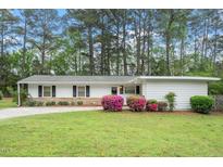Charming single story home with landscaped front yard and colorful azaleas, offers great curb appeal at 911 Williams Rd, Raleigh, NC 27610