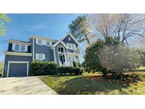 Charming two-story home with a gray exterior, white trim, landscaped yard and a detached garage at 105 Cherry Grove Dr, Cary, NC 27519
