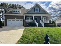 Charming two-story brick home with a well-manicured lawn and attached two car garage at 115 Pecan Harvest Dr, Garner, NC 27529