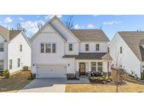 Charming two-story home with an inviting covered front porch and well-manicured landscaping at 1408 Weavers Trace Dr, Zebulon, NC 27597