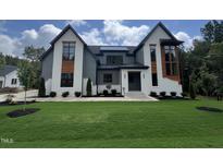 Stunning two-story home featuring a modern design with a lush green lawn and meticulous landscaping at 170 Cherry Bark Dr, Youngsville, NC 27596