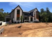 Stunning new construction home boasts a modern design and beautiful curb appeal with large windows and gray accents at 170 Cherry Bark Dr, Youngsville, NC 27596
