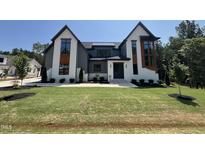 The stunning two-story home has a manicured lawn and modern architectural details at 170 Cherry Bark Dr, Youngsville, NC 27596