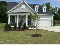 Charming two-story home with gray siding, white trim, a well-manicured lawn, and an attached garage at 190 Salem Village Dr, Fuquay Varina, NC 27526