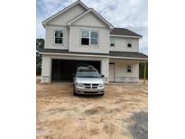 Two-story home featuring an attached garage and light siding complemented by crisp white trim at 228 Dove Rd, Cameron, NC 28326