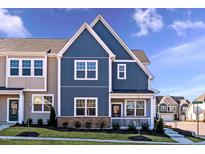 Charming townhome showcasing blue siding, white trim, stone accents, and a welcoming front porch at 2469 Englemann Dr # 366, New Hill, NC 27562