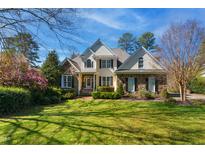 Charming stone and siding home with well-manicured lawn and mature landscaping at 2613 Forest Lake Ct, Wake Forest, NC 27587