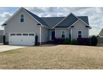 Charming one-story home featuring a two-car garage, landscaped yard and inviting entrance at 30 Wheat Dr, Angier, NC 27501