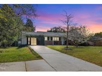 Charming single-story home boasts a well-manicured lawn and inviting brick facade, creating a warm and welcoming curb appeal at 300 Lakeside Dr, Garner, NC 27529
