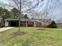 Charming brick home featuring a well-manicured lawn and blooming trees, creating an inviting curb appeal at 300 Lakeside Dr, Garner, NC 27529